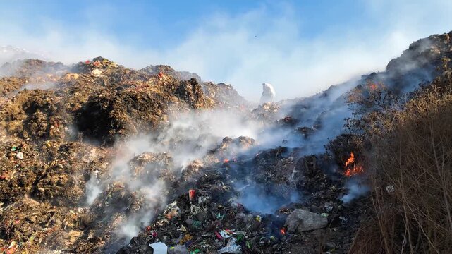 Burning Landfill with Toxic Smoke and Sanitation Workers Segregating Garbage