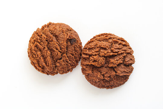 Two chocolate cookies with a unique rippled texture isolated on white.