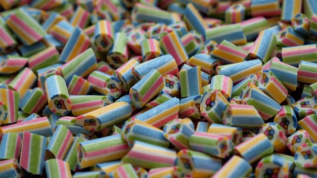 A lot of small, multi-colored, handmade caramel candies in a modern pastry shop. Lollipops or candy with an ice cream pattern inside at a street food festival.