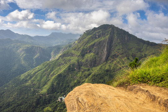 Ella rock mountain, view from Little Adam's Peak in Sri Lanka. Breathtaking panoramic view of lush green mountains under a dynamic sky with scattered clouds