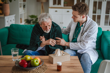 Fototapeta premium Doctor comforting ill senior male patient at home