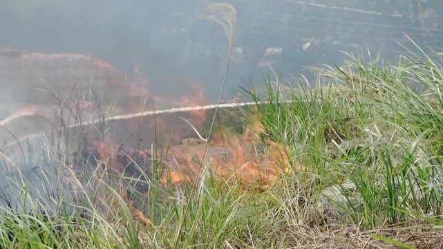 Dry grass on a Taiwanese grave is on fire.