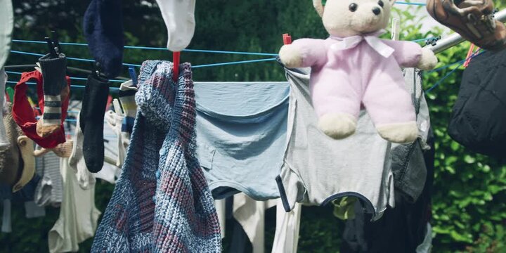 Clothesline with various items hanging from it, including a teddy bear and a pair of shoes.