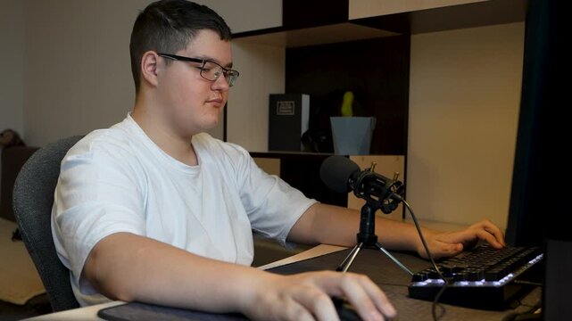 A teenager plays at his computer