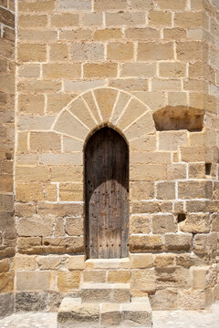 Stone doorway with arch and wall texture medieval architecture in Valderrobres Aragon Spain seen in daylight highlighting rustic heritage surfaces