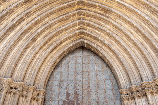 Church portal with gothic arch stone architecture detail in Valderrobres Aragon Spain in daylight highlighting craftsmanship and historic presence