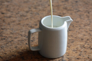 Milk pouring in milk jar.