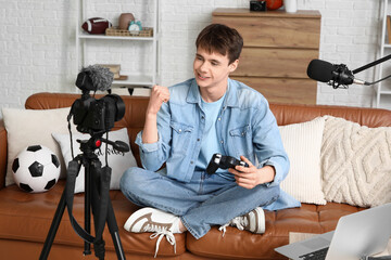 Teenage blogger with game pad recording video on sofa at home © Pixel-Shot