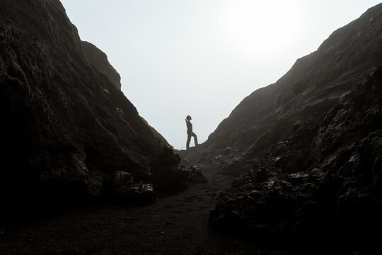 Silhouette of woman standing in misty mountain landscape in Java