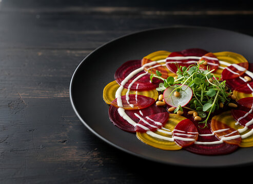Gourmet plant-based beet carpaccio served on a black plate