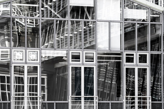 Abstract monochrome architecture glass facade with windows and structure showing reflection lines and pattern in modern industrial framework design