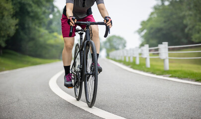 Obraz premium Asian woman cycling in the summer park