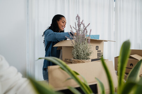 Smiling person packing moving boxes and organizing at home