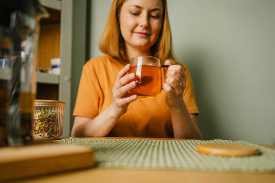 Woman enjoying organic herbal tea indoors at home