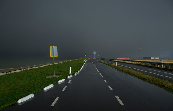 Dark storm clouds over deserted Afsluitdijk dyke road in the Netherlands