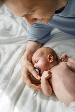 Father bonding with newborn baby at home showing tender affection