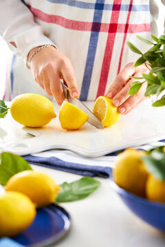 woman hands cutting a lemon in half with a knife