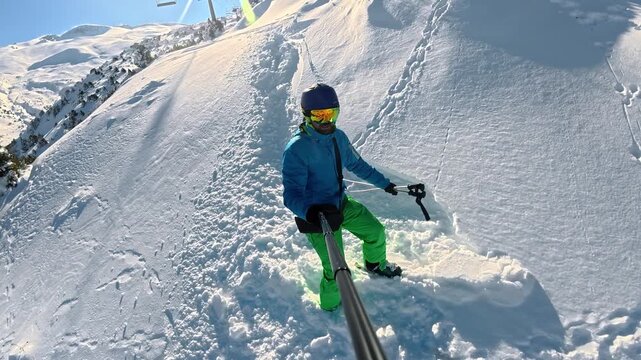 POV style winter action footage of a skier filming himself with an action camera while making first tracks in untouched powder snow on a sunny mountain slope surrounded by pine trees, capturing advent