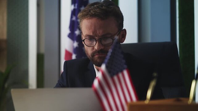 American male government official working on laptop in embassy office, job