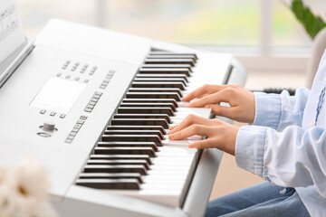 Little girl playing synthesizer at home, closeup © Pixel-Shot