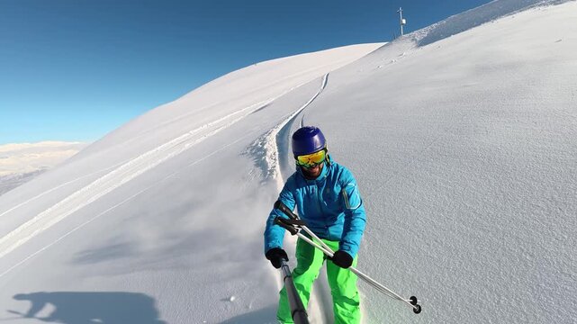 POV style winter action footage of a skier filming himself with an action camera while making first tracks in untouched powder snow on a sunny mountain slope surrounded by pine trees, capturing advent