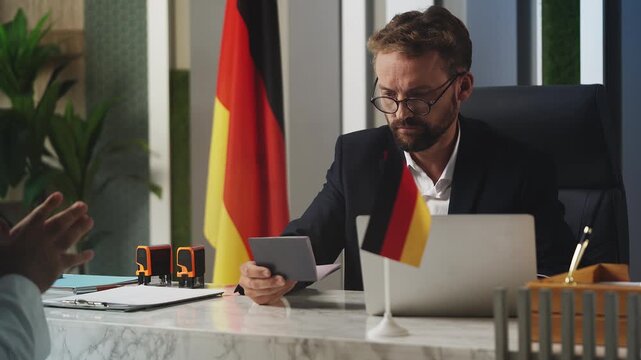 German customs officer checks passport of Arab man, confirms visa application