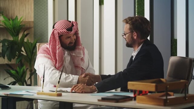 European and Arab men diplomats shaking hands after signing an agreement