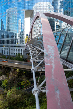 Steel bridge landmark and modern architecture in La Defense Paris France with strong structure lines connecting urban business district and public space