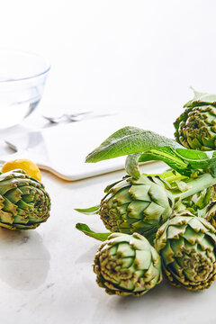 Artichokes on a white table in a kitchen setting