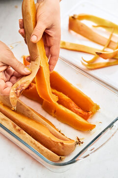 woman hands peeling pieces of pumpkin