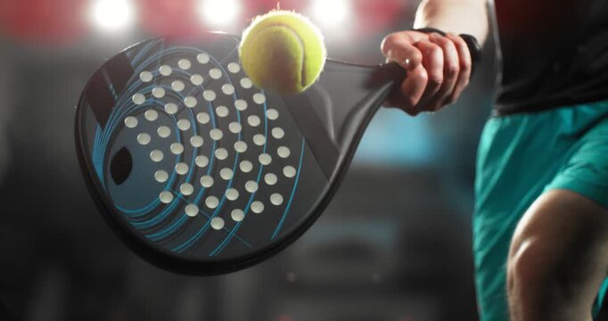 Super slow motion close-up of a hand holding a padel racket as a yellow ball hits the surface, filmed at 1000 fps. Dramatic studio lighting highlights the impact, motion of the racket and ball.