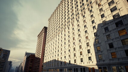 sunlit historic brick facade casting long shadows, contrast between vintage hotel ornament and modern glass tower, tranquil evening mood with textured masonry © icetray