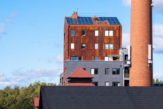 Sustainable building architecture with solar apartment rooftop and smokestack in Stockholm Sweden Djurgardsstaden under clear daylight sky