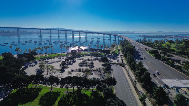 Bay crossing corridor Coronado Bridge spanning San Diego Bay near Tidelands Park and multi lane roadway running parallel to shoreline paths. Smooth pavement, bright bay reflections anchor, CA