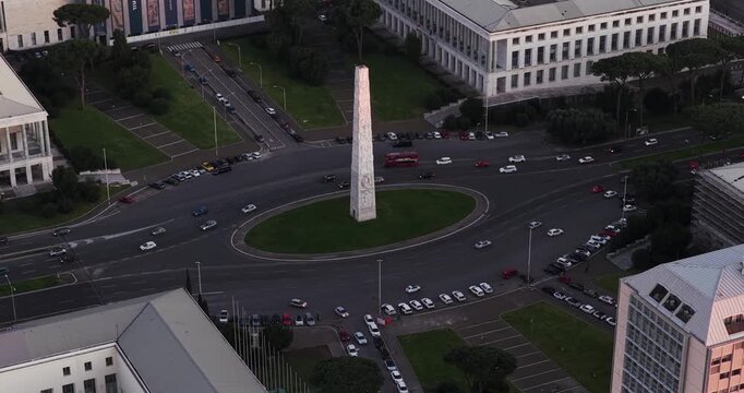 Aerial view of the Marconi Obelisco situated in a roundabout, amidst traffic and buildings, creating a visual contrast, Rome, Lazio, Italy.
