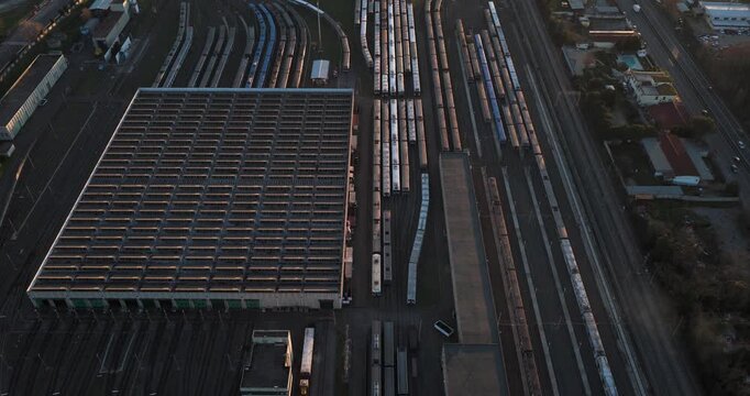 Aerial view of a train yard filled with many train cars and tracks, all set against a backdrop of urban development, Rome, Lazio, Italy.