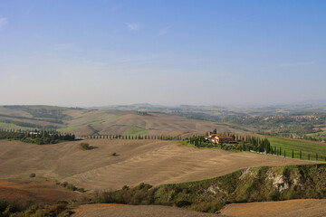 Obraz premium Farmhouse and cypress road in the autumn hills near Asciano, Tuscany, Italy