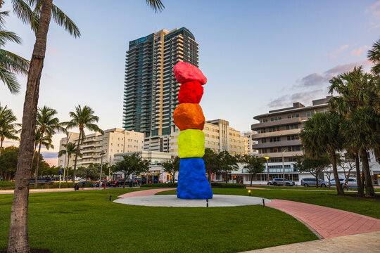 Beautiful view of Ugo Rondinone Miami Mountain colorful stacked rock sculpture in park with city buildings. Miami Beach. USA. 04.15.2025.
