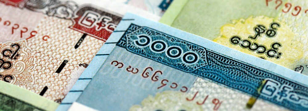 Myanmar kyat paper banknotes pile on table. Myanmar MMK currency money bills in big amount. Concept of economics, taxation and banking in Myanmar