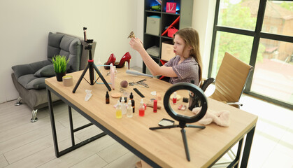 Fototapeta premium In a modern studio, a young artist meticulously arranges beauty supplies, preparing for a vibrant makeup session. The lively atmosphere inspires creativity and self-expression as she works.