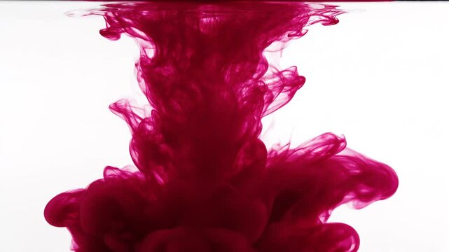 Red ink swirling in water on white background
