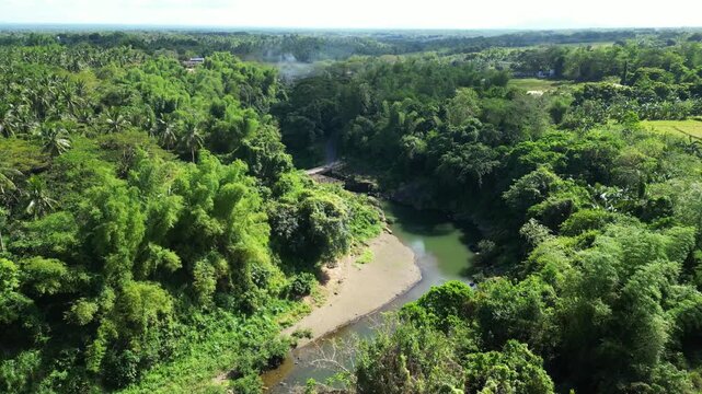 Forward moving drone shot approaching Pantihan Falls surrounded by dense tropical forest in MAragondon Cavite Philippines.