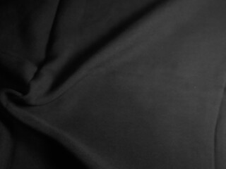 A close-up, high-angle studio shot of elegant black silk or satin fabric