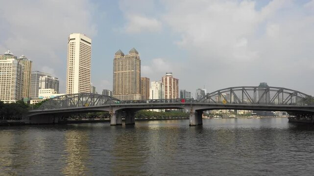 Low backwards drone flight away from historic bridge in Guangzhou city, China