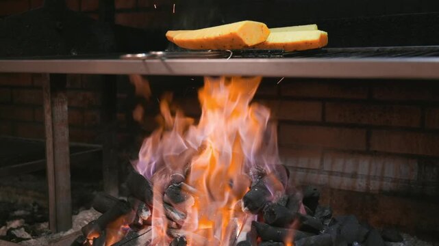Tilt up shot of charcoal grill with food cooking over open fire in restaurant kitchen. High quality FullHD footage