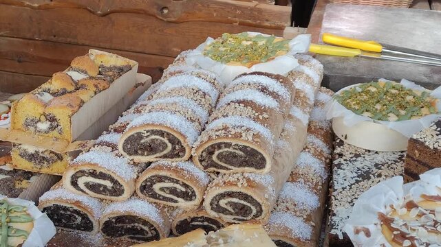 Pokrojony makowiec posypany cukrem pudrem na stole, tradycyjne ciasto z makiem, słodki domowy wypiek do kawy.