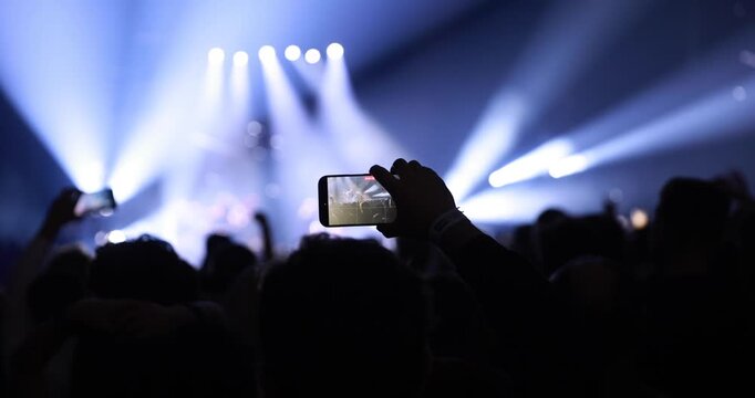 Dynamic lighting design with laser beams and spotlights illuminates the crowd at a music event. Visual effects enhance the professional atmosphere.
