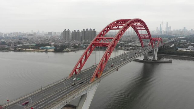 China infrastructure and transportation - drone flight of large arch bridge across the Pearl river with Guangzhou skyline in the background