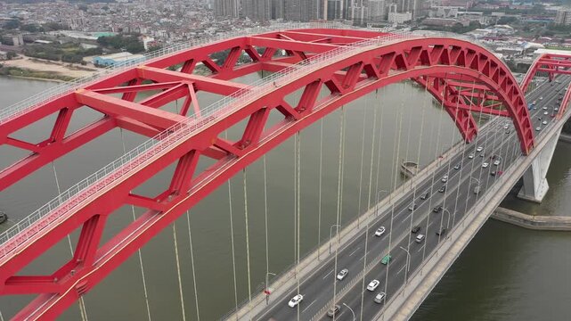Tilting aerial view of cars driving over arch bridge in Guangzhou, engineering and infrastructure in China