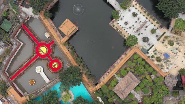 Flying over classic Chinese garden with bridges, ponds, temples in Baomo, Guangzhou China